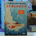Das Buch "22 Bahnen" von Caroline Wahl steht auf einem Tresen.
